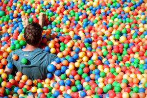 man has fun in a ball pit