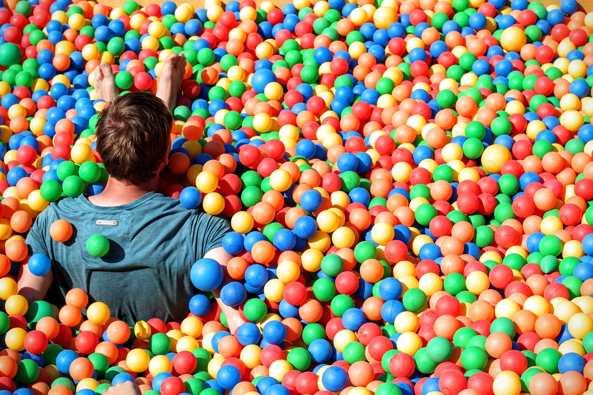 man has fun in a ball pit