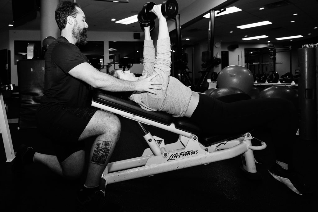 David Turnbull spotting a client on an incline dumbbell press at TurnFit Vancouver