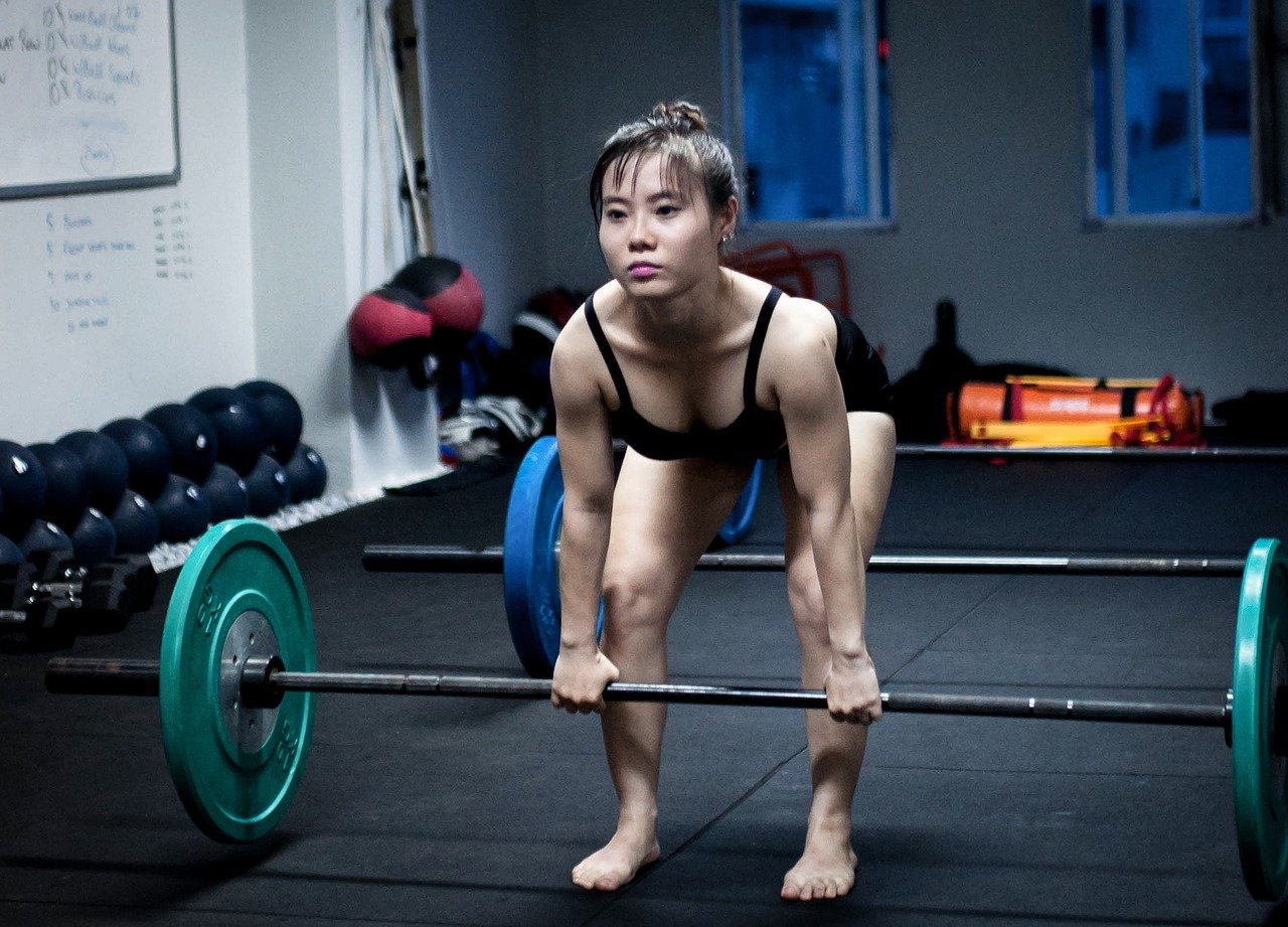 woman doing barbell deadlifts