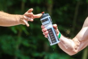 man reaching for water bottle after exercise