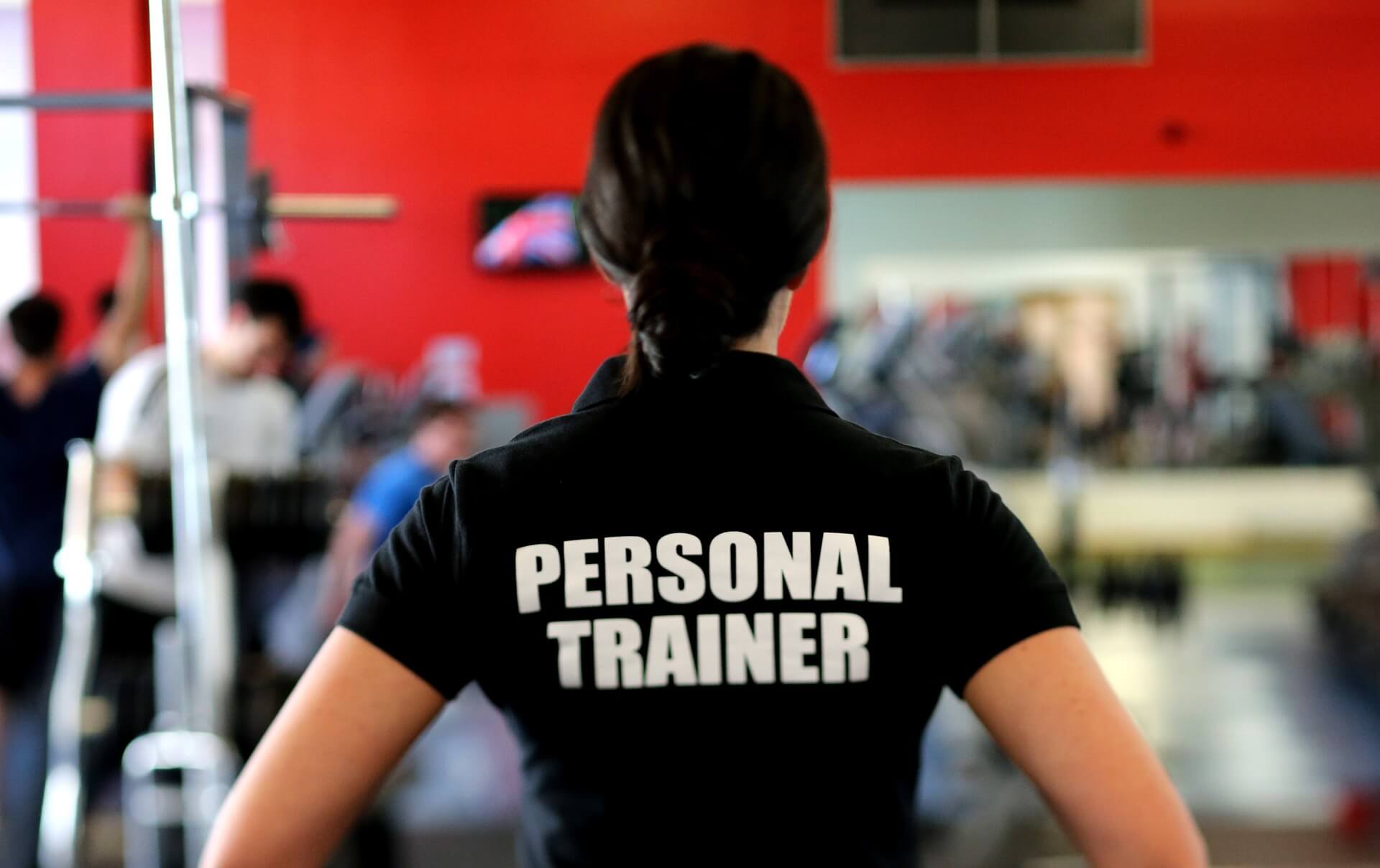 woman in gym wearing personal trainer shirt