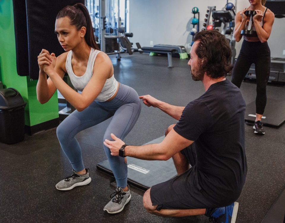David Turnbull coaching a woman through a squat in a one-on-one personal training session in Vancouver